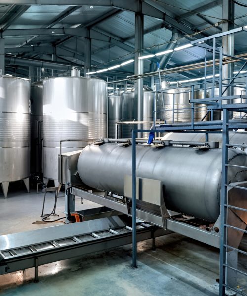 Metal wine storage tanks in a winery. Wide shot